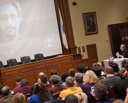 By videoconference, Harvard Professor Lawrence Lessig interviewed Edward Snowden (on screen, photo 1), the former National Security Agency contractor who leaked more than 200,000 classified documents about U.S. surveillance efforts. Lessig (photos 2, 3) used technology to bring Snowden into the crowded Ames Courtroom, where the two spoke frankly about Snowden's actions.