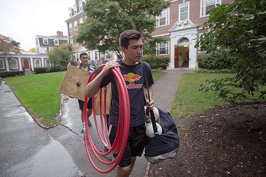 Anthony Ramicone ’15 and Phillip Ramirez ’18 (behind) store the hoop goals in Kirkland House. 