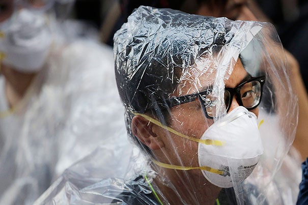 A student pro-democracy protester covers his face in plastic wrap to guard against pepper spray in a standoff with police in Hong Kong on Monday. Protesters expanded their rallies throughout Hong Kong, defying calls to disperse in a major pushback against Beijing's decision to limit democratic reforms in the Asian financial hub.