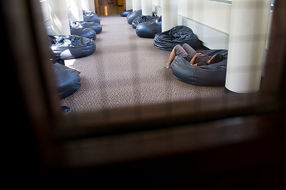 A student rests in a hallway of beanbags at HLS’ Langdell Library.