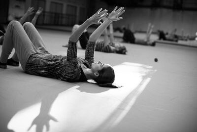 Dance Director and Senior Lecturer Jill Johnson teaches students in the classroom for the Harvard Dance Project. The students rehearse in the Harvard Dance Center at Harvard University. Whitney Cover, Ed.M. '15, (left) warms up during class. Stephanie Mitchell/Harvard Staff Photographer