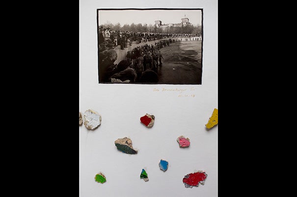In the office of Carl H. Pforzheimer University Professor Robert Darnton hangs a framed postcard featuring a crowd dancing on the Berlin Wall. His teenaged daughter is included in the image. Darnton also added small fragments of the wall in the display. 