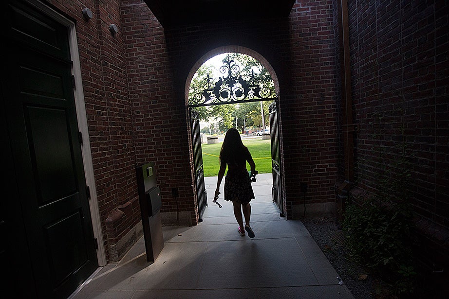 A student with a skateboard passes through the entryway of Leverett House. Kris Snibbe/Harvard Staff Photographer