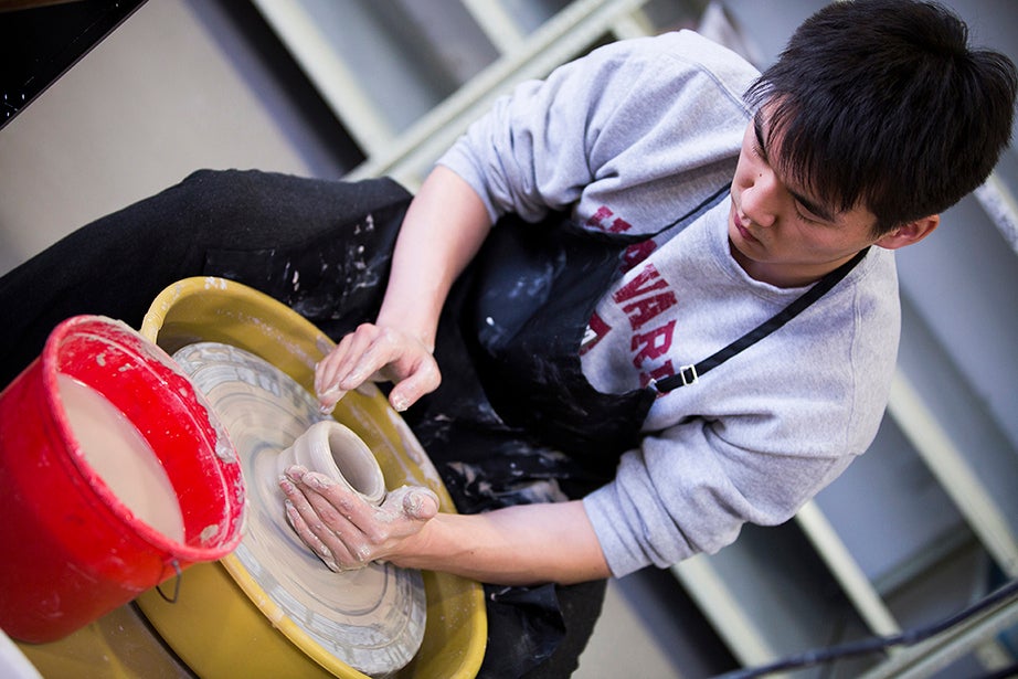 Learning basic ceramic-wheel skills, students wedge, center, and form basic shapes. Perry Choi ’15 (pictured) works on the wheel. Stephanie Mitchell/Harvard Staff Photographer
