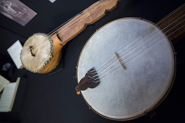 Replicas of a minstrel banjo (foreground, photo 1) and a banza, an African stringed precursor to the banjo, are on view at the Loeb Music Library exhibition. An 1853 map (detail, photo 2) was borrowed from Harvard's Map Collection for the show. Students used the map to help illustrate minstrelsy's wide reach. Samuel Parler (photo 3), a Ph.D. candidate in music, and the chair of Harvard's Music Department Carol Oja conceived of the minstrelsy seminar and resulting exhibition.
