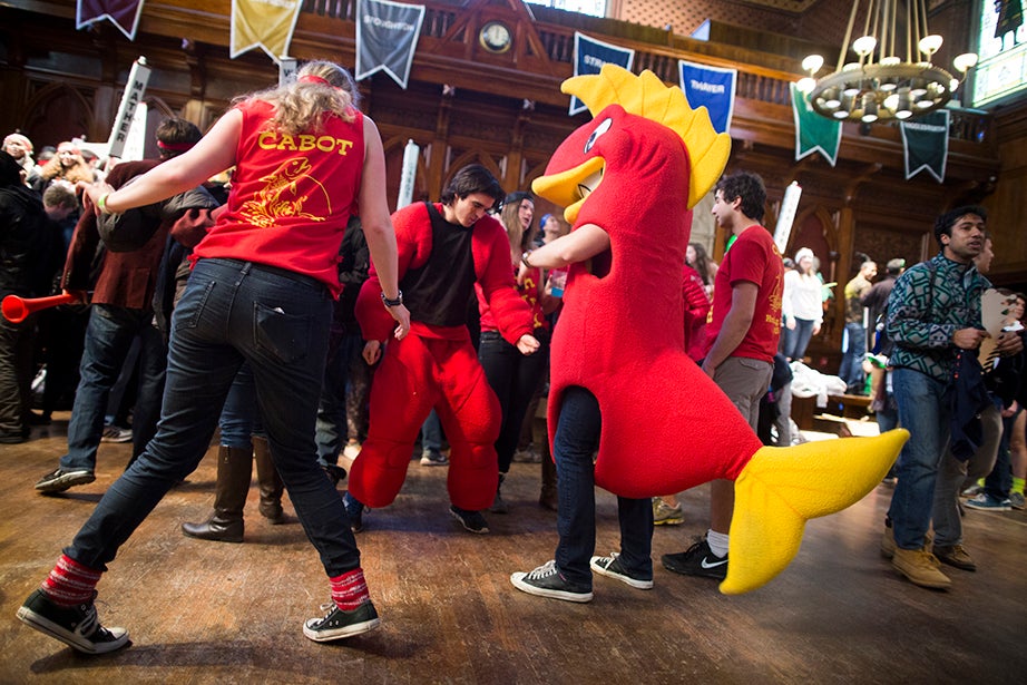 In Annenberg Hall, Lelaina Vogel ’15 (left) from Cabot House dances with Chris Willis ’17, who was dressed as the Cabot House mascot, a fish. Stephanie Mitchell/Harvard Staff Photographer