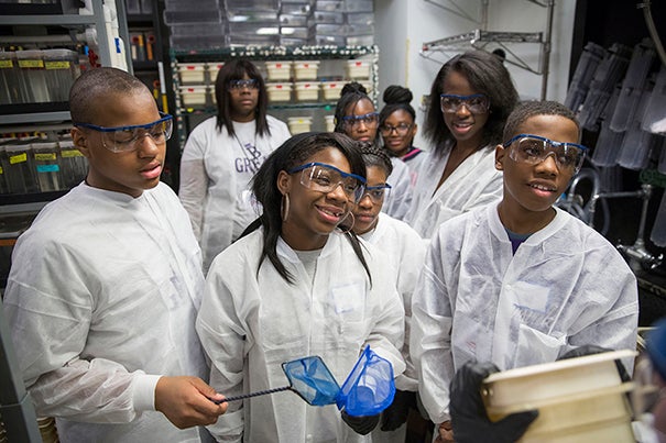Students from Mott Hall Bridges Academy, Jermont Haines, Tukoya Boone, and Aaron Abdulmalik, learn how zebrafish are used in scientific research to study embryonic development with Tessa Montague, GSAS student inside the Biology Labs at Harvard University. In the background is Zion Edwards, (left) Tukoya Boone, Halle Bohner, and Bianca Nfonoyim '15. Harvard University Staff Photo: Kris Snibbe