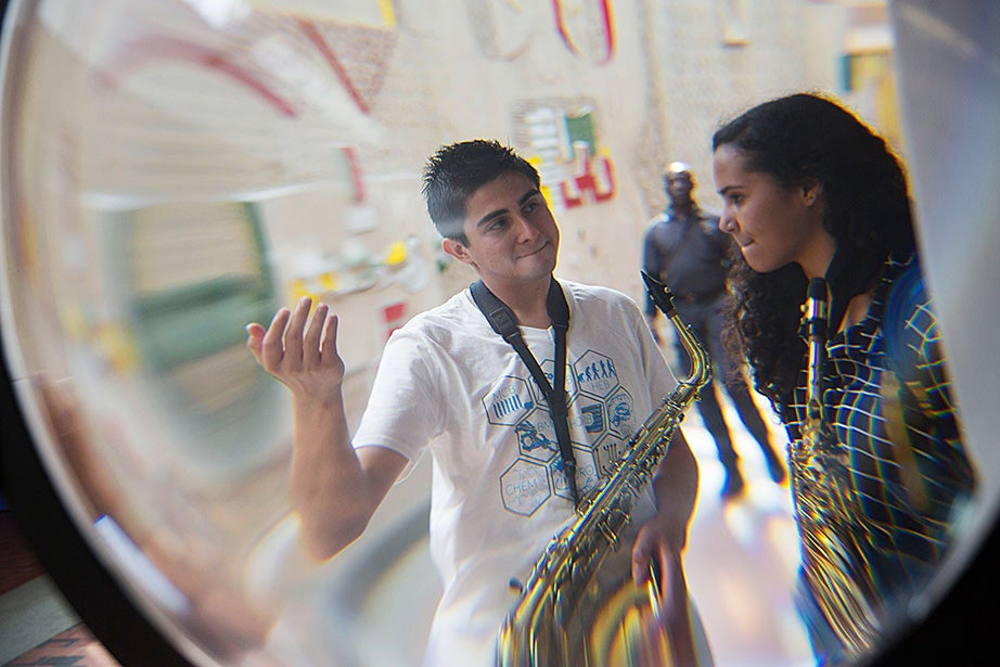 Ninth-grader Mariah Goldsmith is framed by a water lens in the Science Center while discussing an upcoming performance with her tutor, David Armenia. 