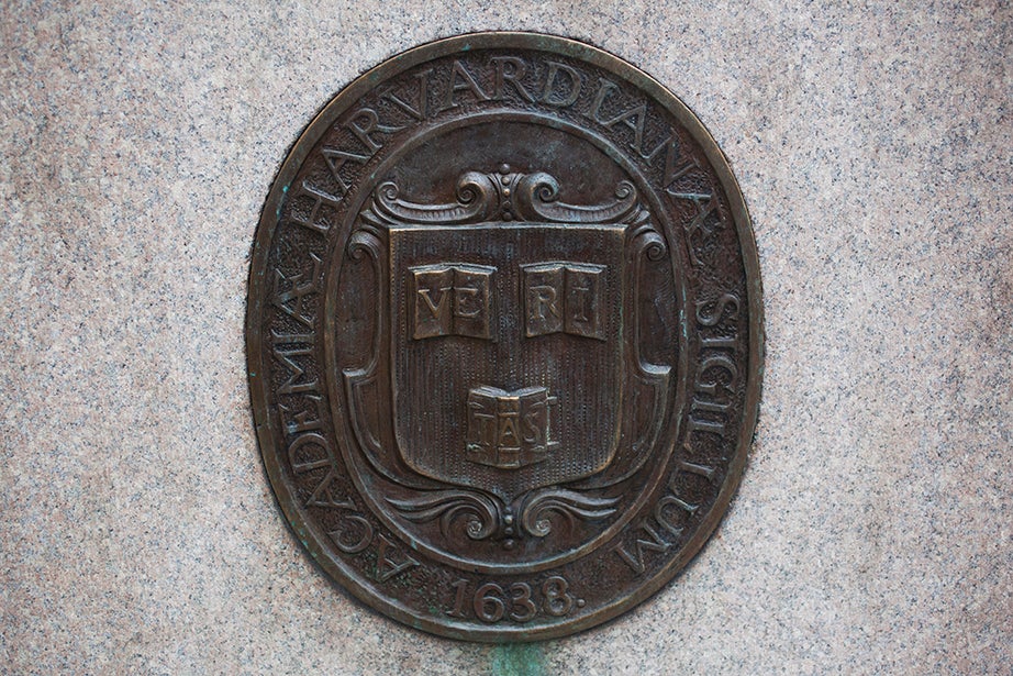 A Veritas shield on the John Harvard Statue follows the original 1643 design for the three books: two open and one turned over. 