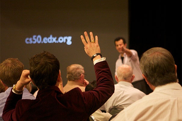 David Malan (facing audience), the Gordon McKay Professor of the Practice of Computer Science, discusses his introductory computer science course, CS50, with alumni in Texas.
