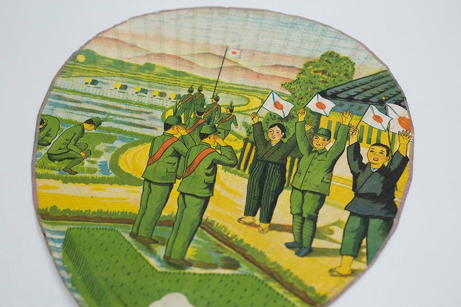 Japanese nationalism is evident on this fan featuring soldiers and workers with the Japanese flag.