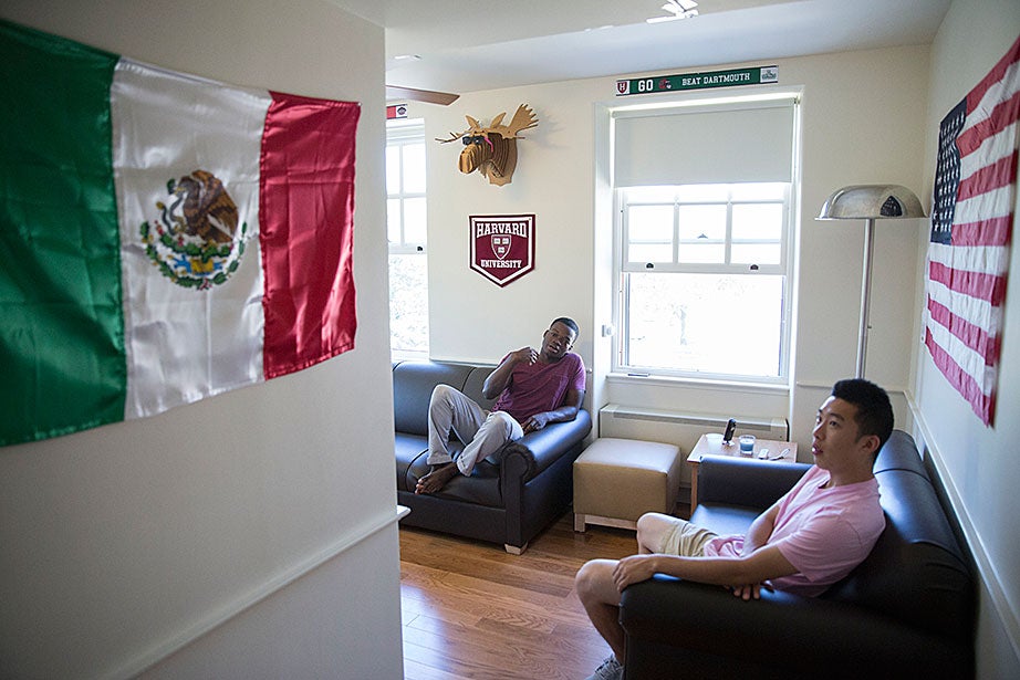 Kevin Chen ’17 (pink shirt), Ayomide Opeyemi ’17, and their roommates decorate their room with flags of Mexico and the United States. Kris Snibbe/Harvard Staff Photographer