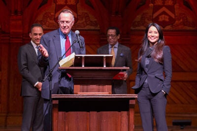 Dean William Fitzsimmons introduces actress and philanthropist Lucy Liu as the Harvard Foundation's 2016 Artist of the Year. Jonathan Sands '17 (left) and Harvard Foundation Director S. Allen Counter are pictured in the background. 