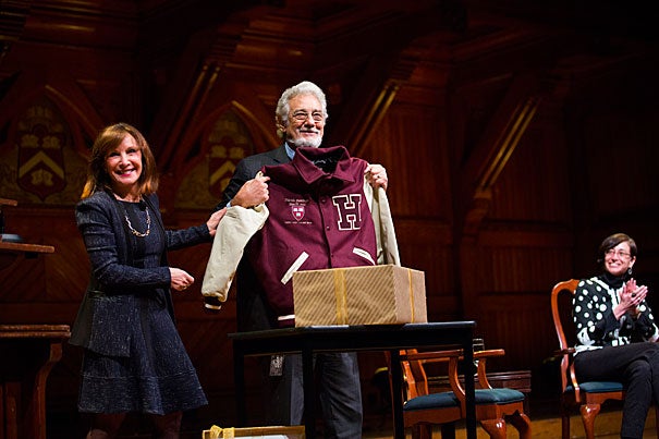 Opera singer Plácido Domingo spoke about his career in a conversation at Sanders Theatre called "Giving Voice." Diana Sorensen (left), dean of arts and humanities, presented Domingo with a Harvard jacket. Professor Tamar Herzog (right) also participated in the conversation. 