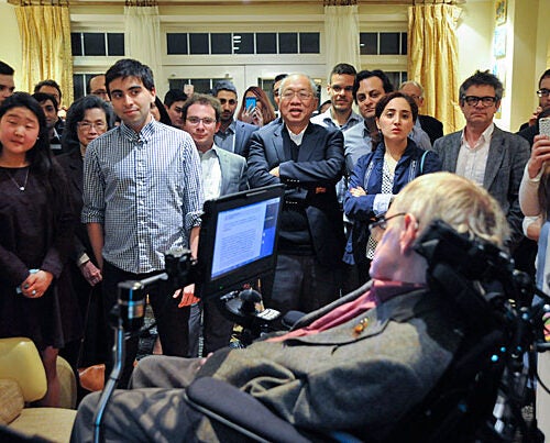 Students and faculty, including Keyon Vafa '16 (second from left), gather to view a slide show and presentation by Stephen Hawking. Cumrun Vafa, Donner Professor of Science, hosted a dinner at his home in Newton in honor of Hawking's visit to Harvard. 