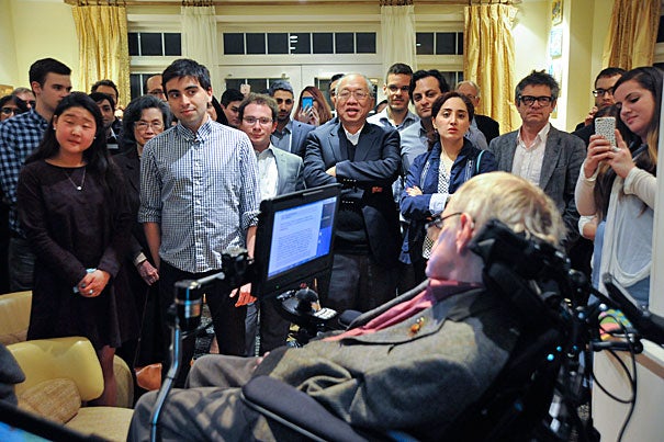 Students and faculty, including Keyon Vafa '16 (second from left), gather to view a slide show and presentation by Stephen Hawking. Cumrun Vafa, Donner Professor of Science, hosted a dinner at his home in Newton in honor of Hawking's visit to Harvard. 
