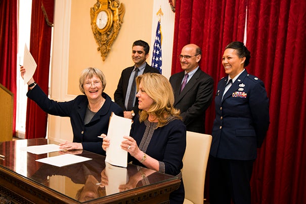 Harvard President Drew Faust (left) and Secretary of the Air Force Deborah Lee James celebrate the return of the Air Force ROTC program to campus with a ceremonial signing.