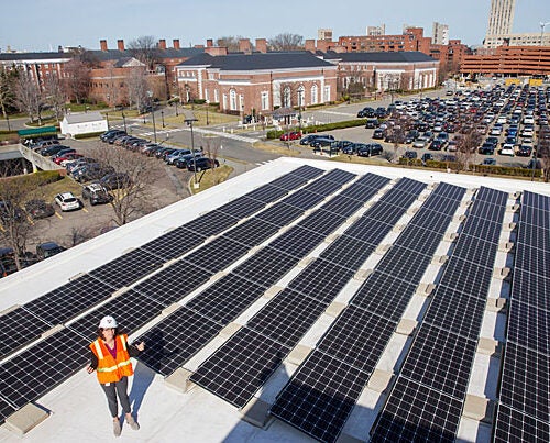 Standing on the roof of Batten Hall, Julia Musso, the energy and sustainability coordinator for Harvard Business School, shows an array of 113kW solar panels that provide energy for the HBS campus. In 2015, HBS also installed solar panels on its Travis Street building and a new solar thermal unit on the roof of Esteves Hall that uses heat from the sun to provide hot water. The University’s Schools and departments have installed more than 1MW of solar panels on rooftops across Harvard’s campus, including at the Harvard Athletics Complex, Canaday Hall in Harvard Yard, the Divinity School, the Graduate School of Education, Harvard Forest, and Arnold Arboretum.
