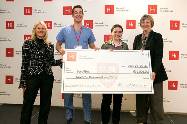 SurgiBox was named the winner of the 2016 President’s Challenge. Jodi Goldstein (left), director of the Harvard i-lab, and Harvard President Drew Faust (right) presented the award check to SurgiBox team members Christopher Murray and Madeline Hickman.