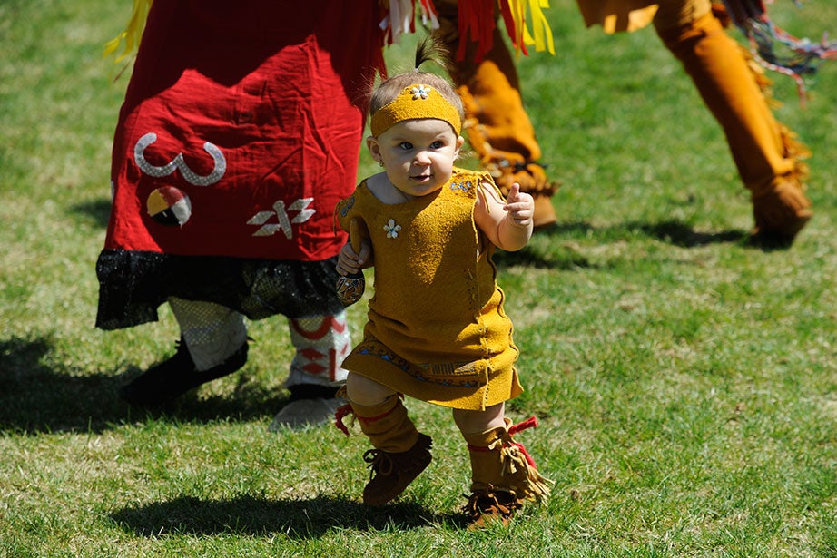 Braelin Lettner, 14 months, a Nipmuc from Palmer, Mass., joins in the dancing at the 21st annual Harvard Pow Wow in Radcliffe Yard. Seated in Grafton, Mass., the Nipmuc Nation claims more than 500 citizens. 

