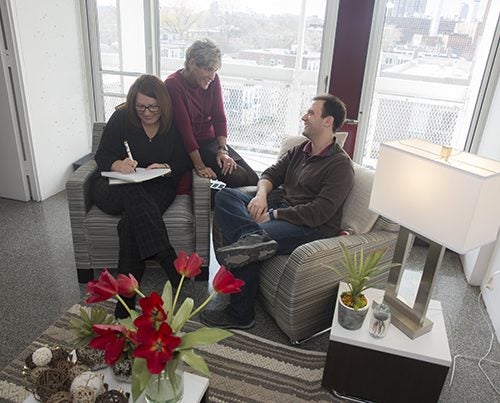 Kathryn Deveau (from left), Harvard University Housing Property Manager, talks with area manager Pamela Cornell (center) and Matheus Fernandes, doctoral student in the Harvard John A. Paulson School of Engineering and Applied Sciences. They are sitting on furniture free of chemical flame retardants, which is being added to Peabody Terrace’s furnished apartments as part of a renovation project.