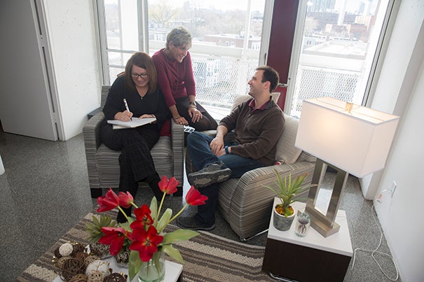 Kathryn Deveau (from left), Harvard University Housing Property Manager, talks with area manager Pamela Cornell (center) and Matheus Fernandes, doctoral student in the Harvard John A. Paulson School of Engineering and Applied Sciences. They are sitting on furniture free of chemical flame retardants, which is being added to Peabody Terrace’s furnished apartments as part of a renovation project.