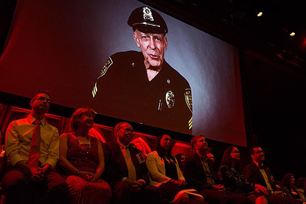 The image of Sergeant Dan Twomey appears above his fellow Harvard Heroes. Sixty-three University staff members were honored for their contributions to Harvard during a ceremony at Sanders Theatre.