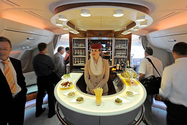 Stewardess Nadine Schumacher (center) works at the bar in the first-class section of an Emirates Airline Airbus A380 passenger plane. Research co-authored by Harvard Business School's Michael I. Norton has found that flights separating passengers into first- and economy-class cabins are more likely to see incidents of air rage.