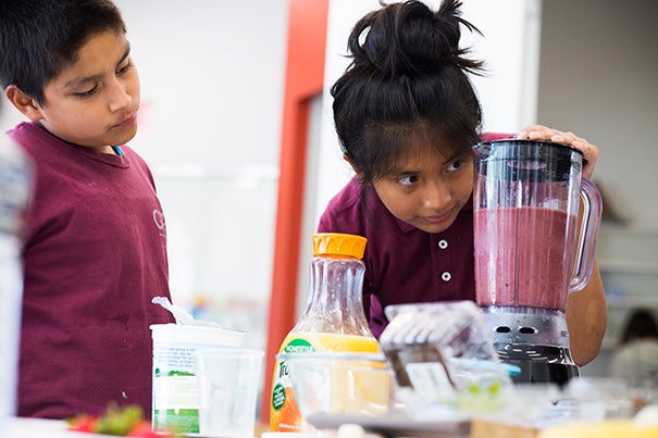 Luis Agulion (left) and Jennifer Mauricio keep an eye on their latest science project at the Harvard Ed Portal's “Science and Cooking for Kids” program.