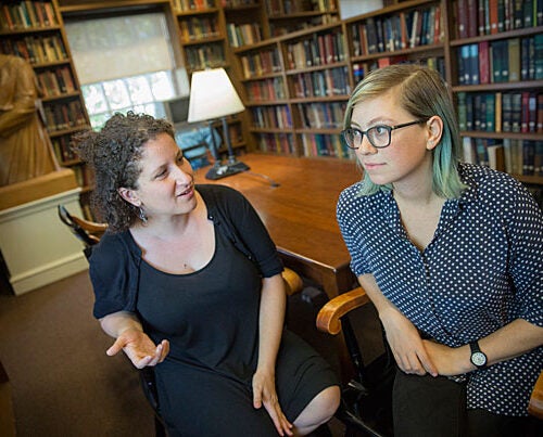 Inside the Dudley House library, Vanessa Zoltan, M.Div. '15 (left), proctor and member of the Board of Freshman Advisers, and Ariana Nedelman, M.Div. candidate '18, HDS staff member, discuss their new podcast "Harry Potter and the Sacred Text," which looks at the famous books as instructive and inspirational texts. 
