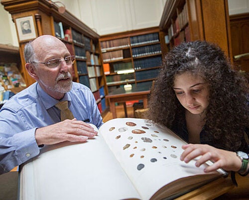 Inside the Harvard University Herbaria's Farlow Library, Professor Don Pfister (left) and Hannah Zurier '17 discuss a recently published article about her work discovering a new truffle fungus at the Arnold Arboretum. 