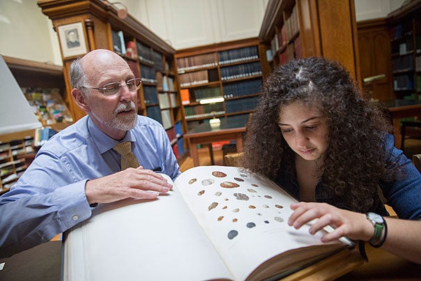 Inside the Harvard University Herbaria's Farlow Library, Professor Don Pfister (left) and Hannah Zurier '17 discuss a recently published article about her work discovering a new truffle fungus at the Arnold Arboretum. 
