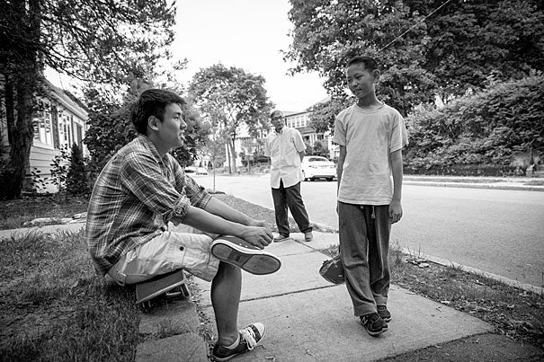 Incoming Harvard freshman, Kevin Yang with his brother, Neil Jin, outside their West Roxbury home. Their grandfather, Yongshou Jin, is in the background. Rose Lincoln/Harvard Staff Photographer