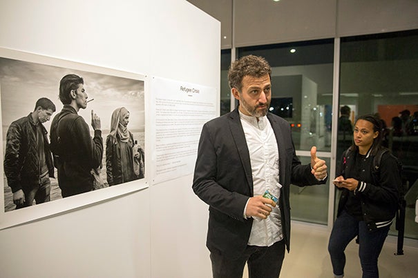 Maciek Nabrdalik (left)  Nieman Fellow and documentary photographer, speaks about his exhibit, "Refugee Crisis," at the Crossings Gallery at the Harvard EdPortal. “I don’t treat it as artwork. It’s not a show that I would like you to ... compliment me for."
