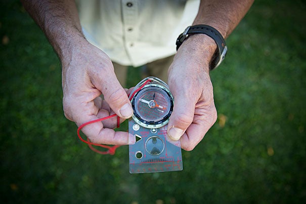 John Huth displays the compass he used in his trek through the Alps. Photo by Sarah Silbiger
