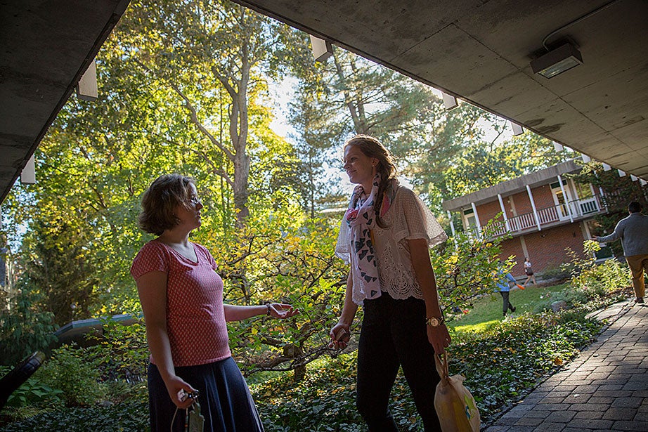 Melissa Coles (from left) and teaching fellow Laura Thompson have a heart-to-heart in the courtyard. 