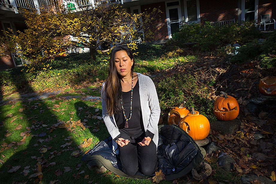 Jack-o’-lanterns look on as Vicky Lee, M.Div., practices Kriya Yoga mudras and breathing exercises in the CSWR courtyard. Lee, a Christian, incorporates yoga and meditation into her spiritual practice. 