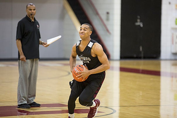 Harvard senior and basketball standout Siyani Chambers '17 directs the offense at practice as coach Tommy Amaker watches the play. Chambers is back on campus after taking a year off from school to recover from an ACL tear. 