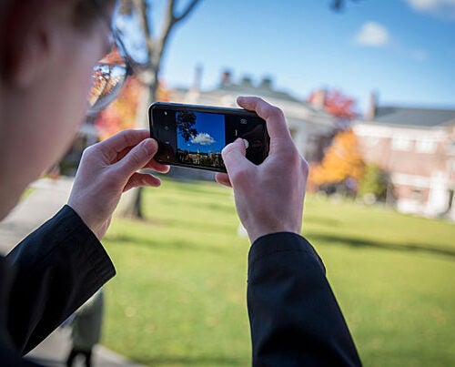 Jasper Johnston '20, creator of the Instagram photography project "100 Days of Harvard," snaps a photo from the steps of Longfellow Hall in Radcliffe Yard.