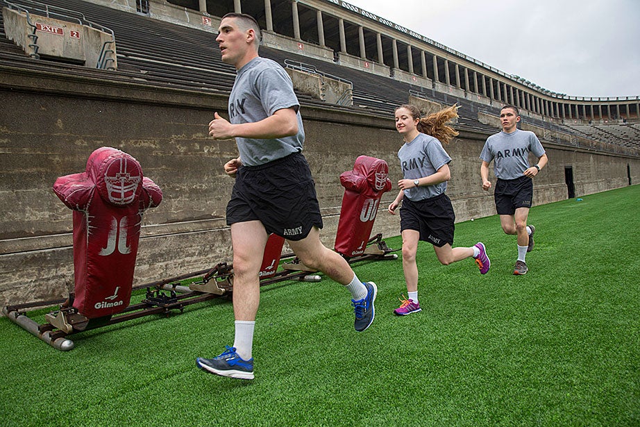 Framed by football training equipment, Luke Pumiglia ’17 (from left), Alannah O’Brien ’19, and Nathan Williams ’18 run together at the Harvard Stadium. “I joined Army ROTC in order to help shape future military policy,” said Williams, “Through Army ROTC, I’ve entered a tight-knit community of cadets who not just push one another to their physical limits, but also never hesitate to help one another during times of need.” 