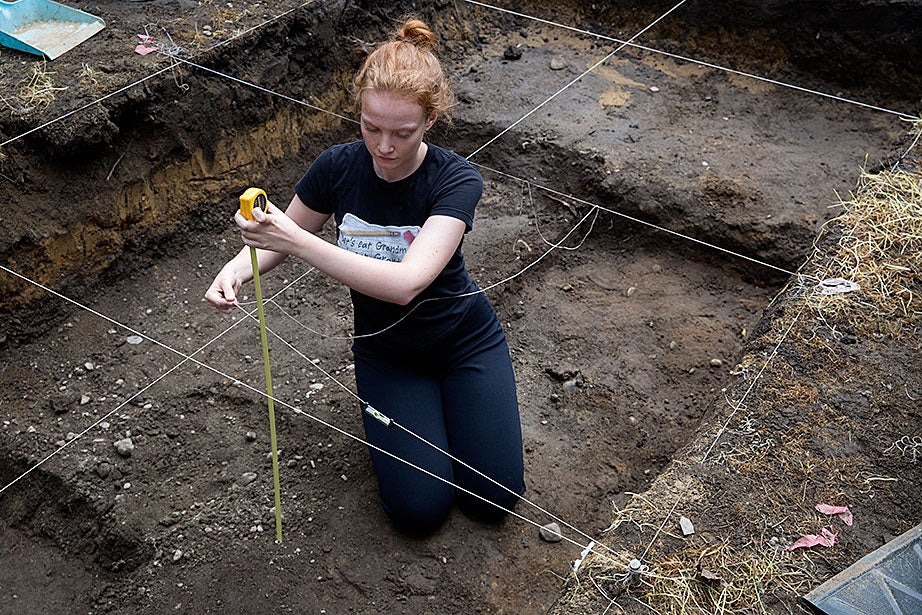 Ailie Kerr ’20 measures the depth of her unit: 67 cm. The excavation proceeds in a precisely organized fashion, with the bottom of the pit always being kept level.