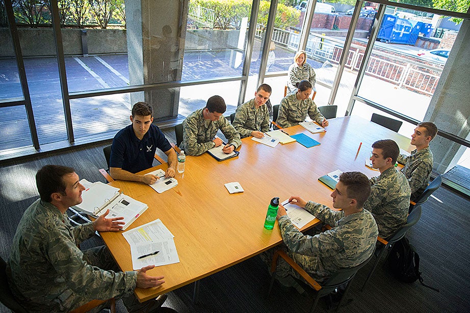 U.S. Air Force Maj. Michael Clifford (clockwise from far left), an assistant professor in aerospace studies at MIT, teaches cadets Ryan Comrie ’19, Peter Hartnett ’19, both from Harvard; Ryan Friedman ’19, from Tufts; Jordanne Stobbs-Vergara ’19, of Wellesley; and MIT students Matthew Hutchinson ’19, Riley Steindl ’19, Alexander Knapp ’19, during Air Force ROTC academic classes and Leadership Laboratory inside the Harvard Student Organization Center at Hillis. Commander Sheryl Double Ott of the Air Force ROTC Detachment 365, a visiting professor at MIT (upper right), looks on. 