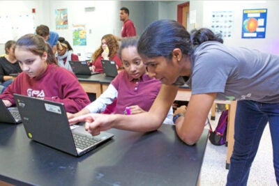 Suriya Kandaswamy '20, who intends to concentrate in computer science, explains a coding problem to Gardner Pilot Academy seventh-grader Diamonique Marmoucha during a Digital Literacy Project lesson.