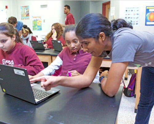 Suriya Kandaswamy '20, who intends to concentrate in computer science, explains a coding problem to Gardner Pilot Academy seventh-grader Diamonique Marmoucha during a Digital Literacy Project lesson.