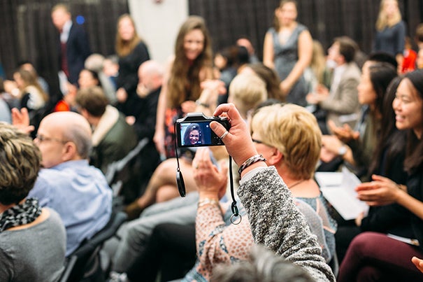 A proud family member snaps a photo as graduates stand to be recognized at the Midyear Graduates Recognition Ceremony on December 2, 2016. Photo by Will Halsey