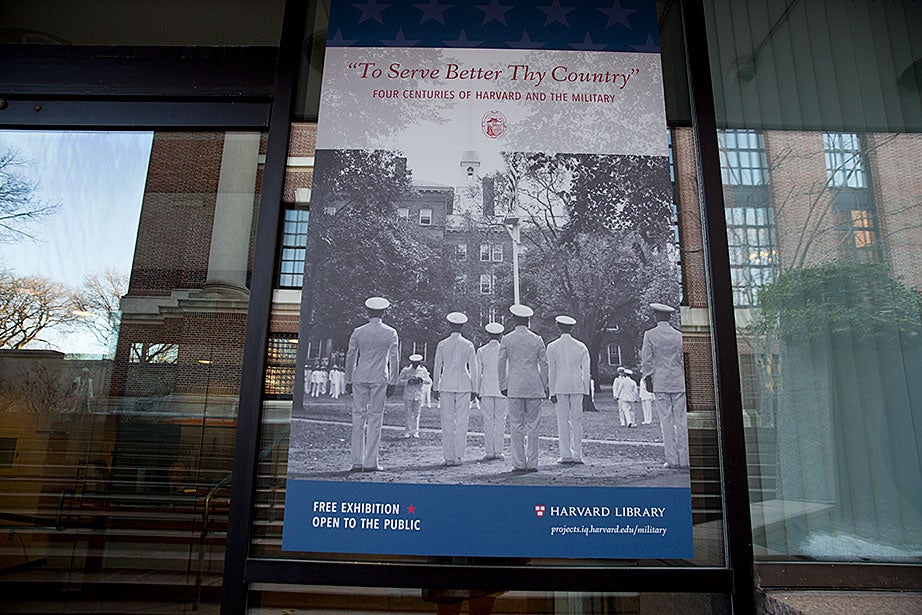 A sign welcoming visitors to the exhibit at Pusey Library shows a group of cadets from the first graduating class of the Naval Training School at Harvard in 1942.