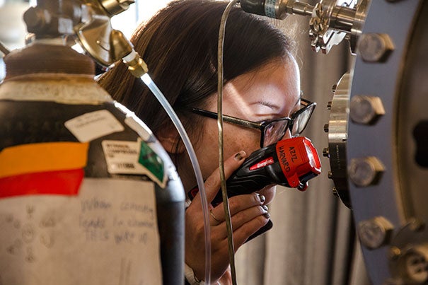 An attendee at the Conference for Undergraduate Women in Physics examines equipment in the lab of Michael J. Aziz, the Gene and Tracy Sykes Professor of Materials and Energy Technologies.
