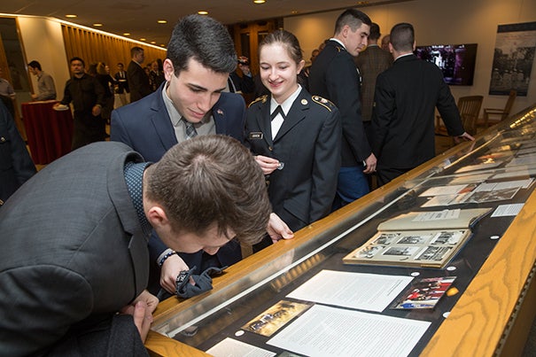Reception for the Pusey Library archives exhibit “To Serve Better Thy Country”. Boris Davidov '19, front center, and Alannah O'Brien '19, front right, look over the exhibit. Attendees: University leadership TBC; undergraduate ROTC cadets and midshipmen; student veterans; Harvard University Veterans Organization and Alumni Organization members; faculty with ties to military; HPAC staff; University Archives staff. Jon Chase/Harvard Staff Photographer