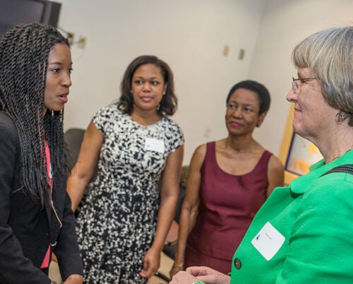 Harvard College graduate Shaunte Butler '14 (left), welcomes Harvard President Drew Faust to Miami Northwestern High School. Shaunte, who graduated from Northwestern, joined Faust to speak to current students about pursuing higher education. 