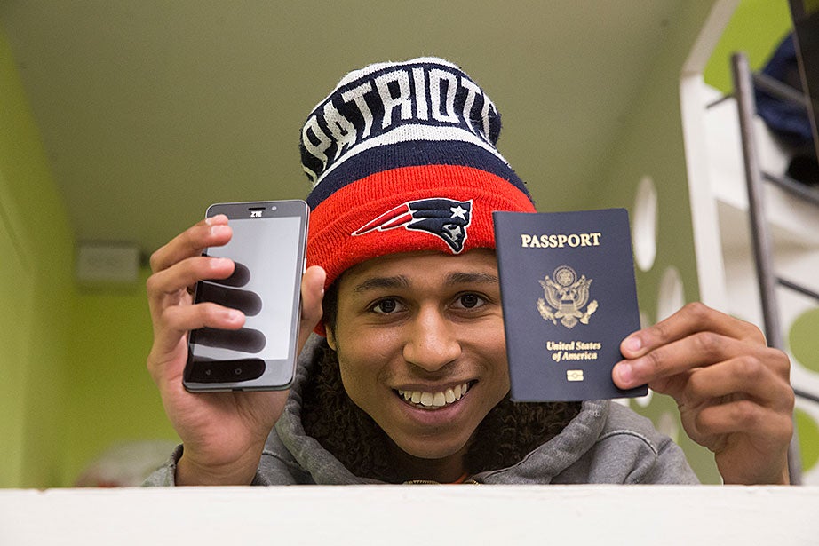Michael displays his two most prized possessions, his phone and passport. Michael traveled to France recently to visit his aunt, who lives in Nice and paid his way. Michael is an avid Patriots fan, and recounts past playoff games with great passion, acting out plays by quarterback Tom Brady. 